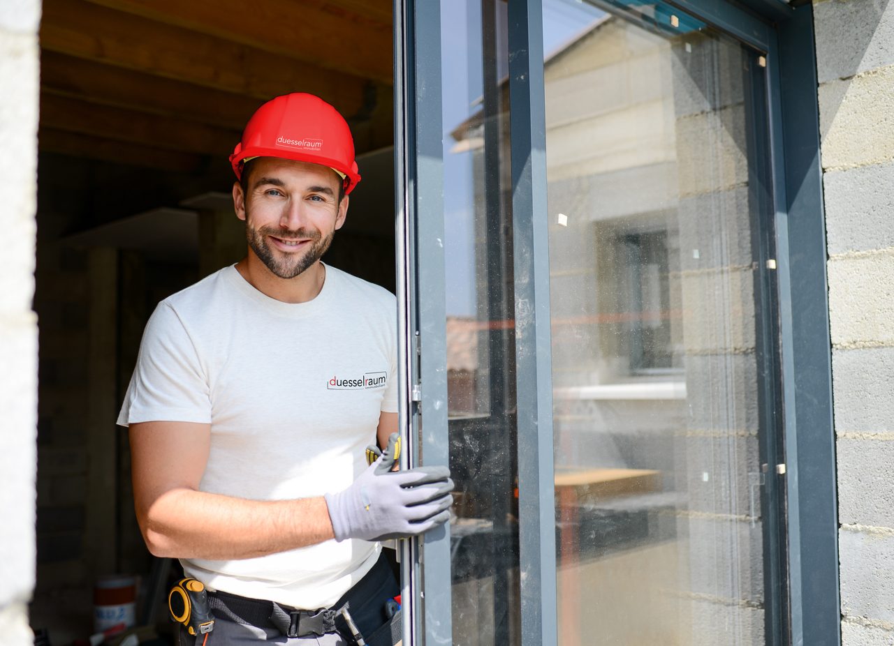 Ein Handwerker von duesselraum Immobilien bei der Installation einer Terrassentüre