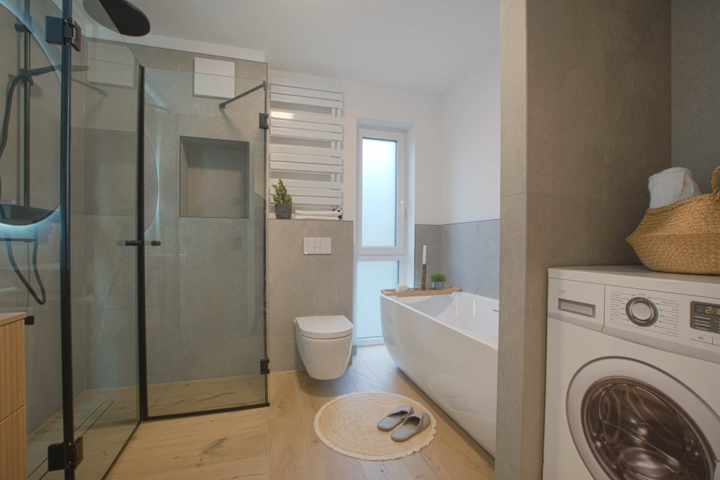 Badezimmer mit großer Dusche, Badewanne und Waschmaschinenanschluss