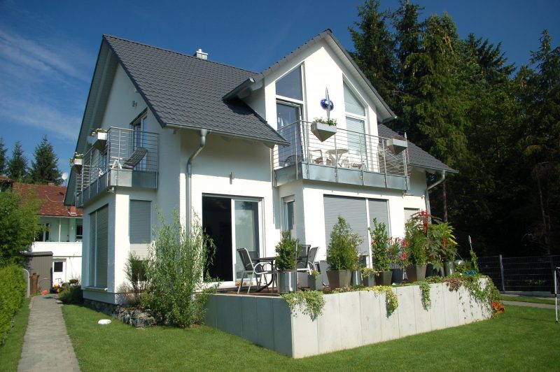 Einfamilienhaus mit weißer Fassade und grauem Dach