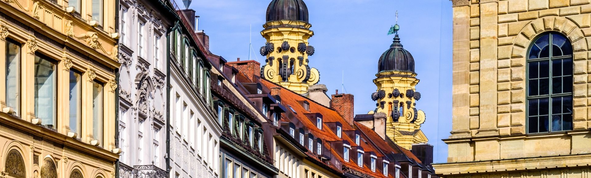 Historische Münchner Altstadt mit prachtvollen Fassaden, roten Dächern und markanten Kirchtürmen im Stadtbild von München