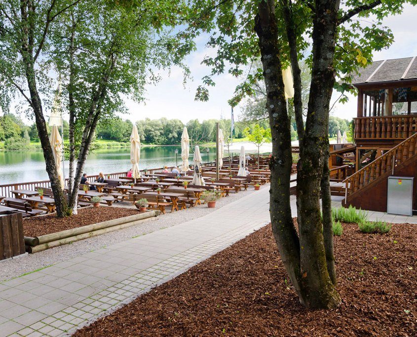 Biergarten am Ufer eines Sees im Grünen