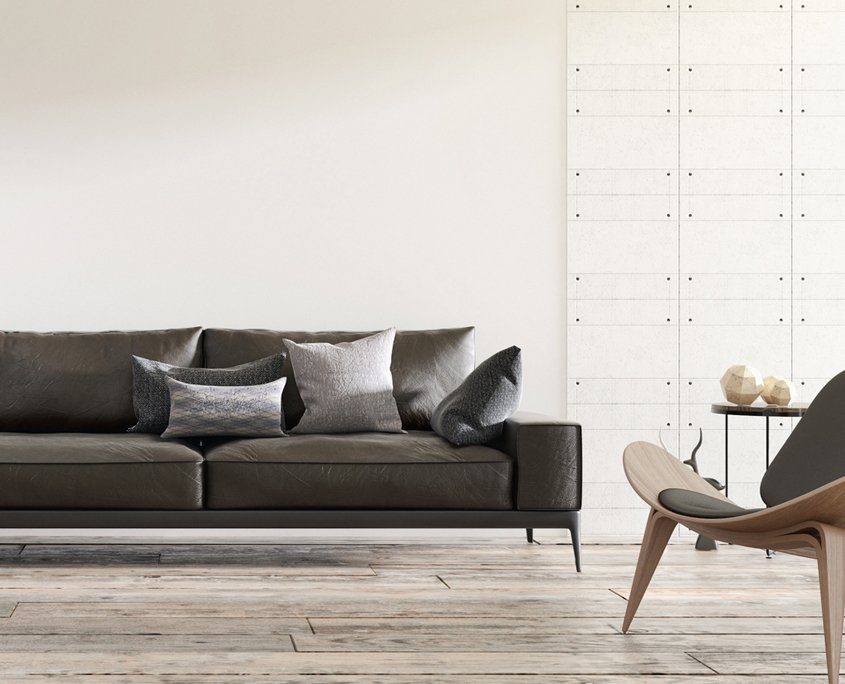 Dunkelgraue Couch vor weißer Wand