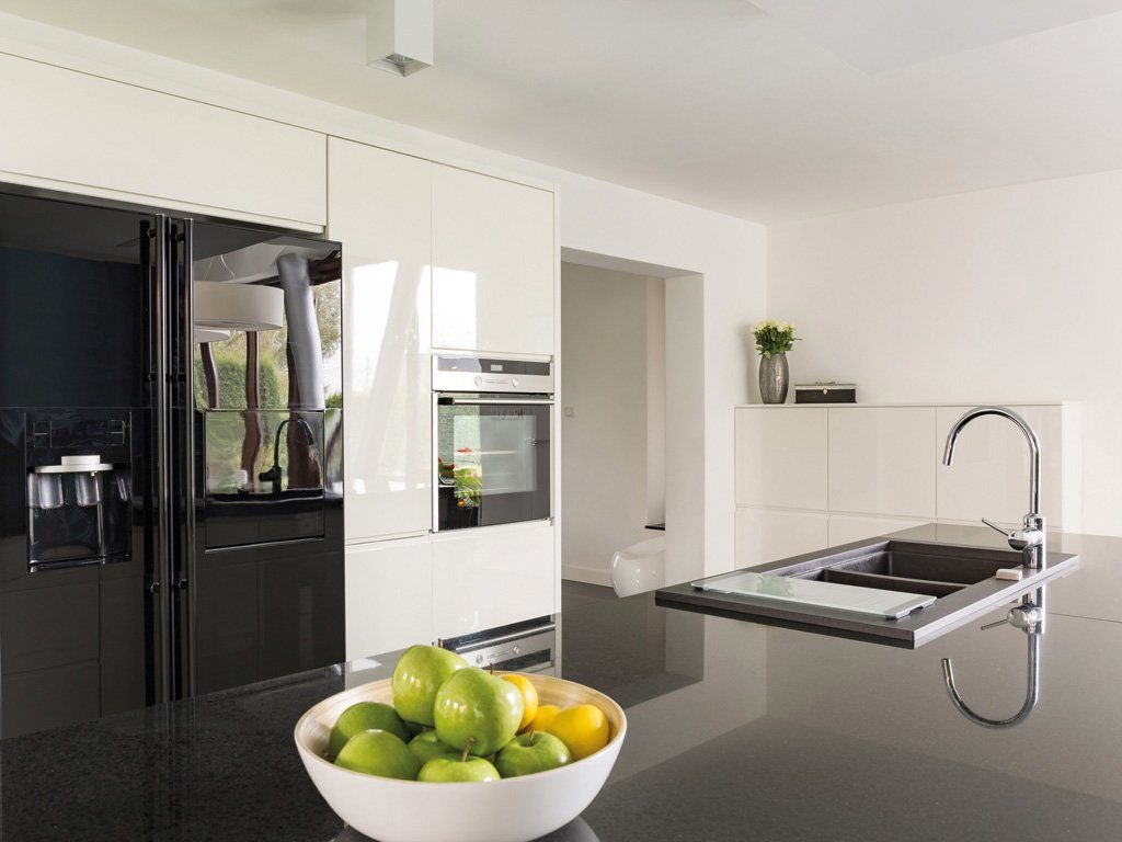 Elegante Küche mit schwarz glänzender Arbeitsplatte und modernen Armaturen