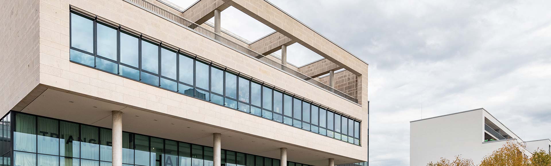 Hausfassade mit großer Fensterfront und Dachterrasse