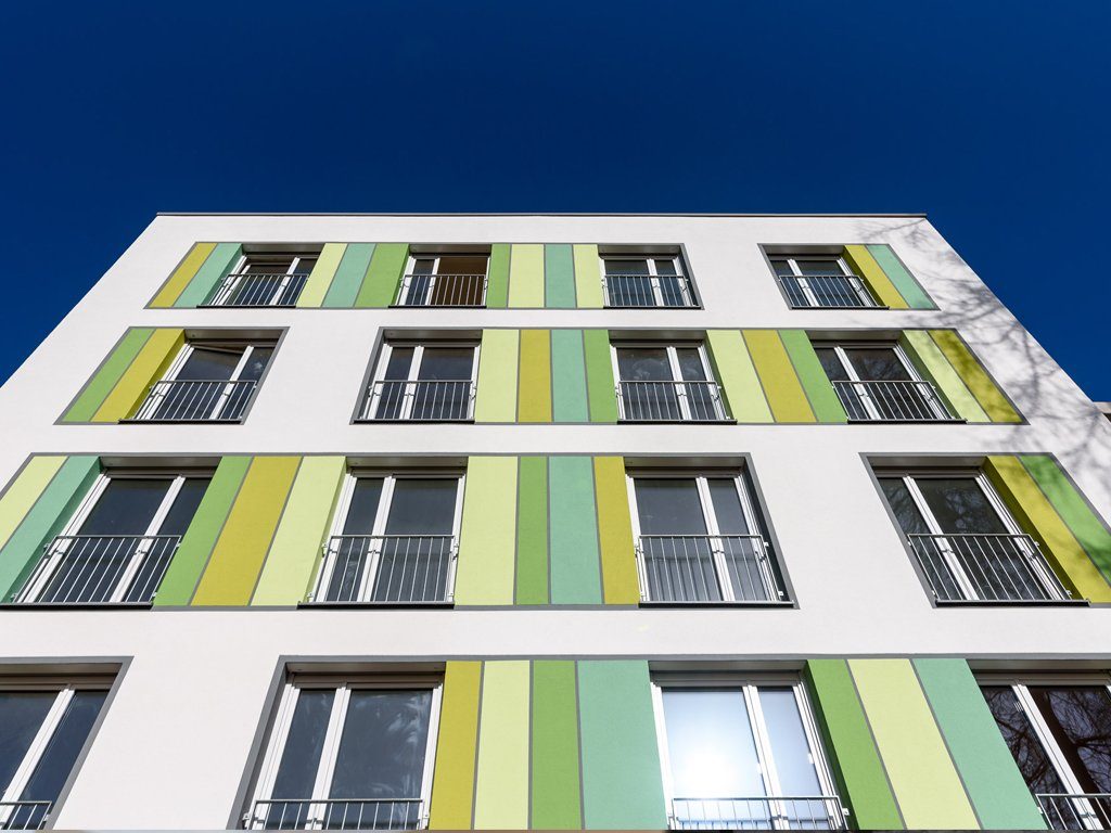 Modernes Wohnhaus mit bodentiefen Fenstern und hellgrünen Deko-Elementen