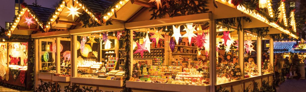 Verkaufsstand auf einem Weihnachtsmarkt mit vielen bunt leuchtenden Papiersternen