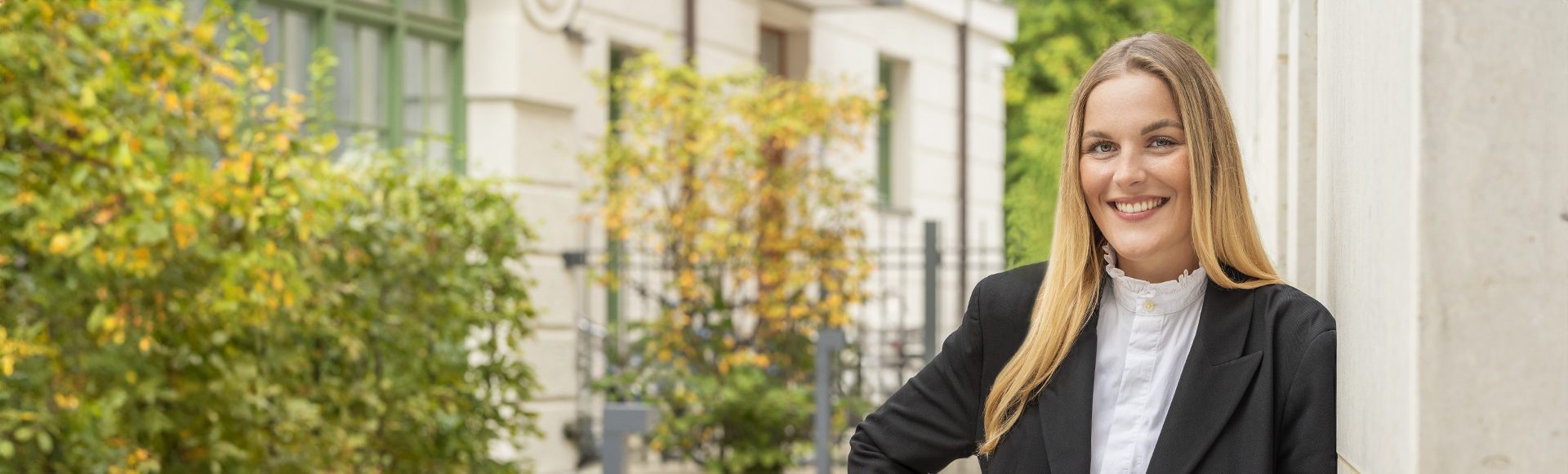 Immobilienmaklerin bei Aigner Immobilien lächelt in die Kamera
