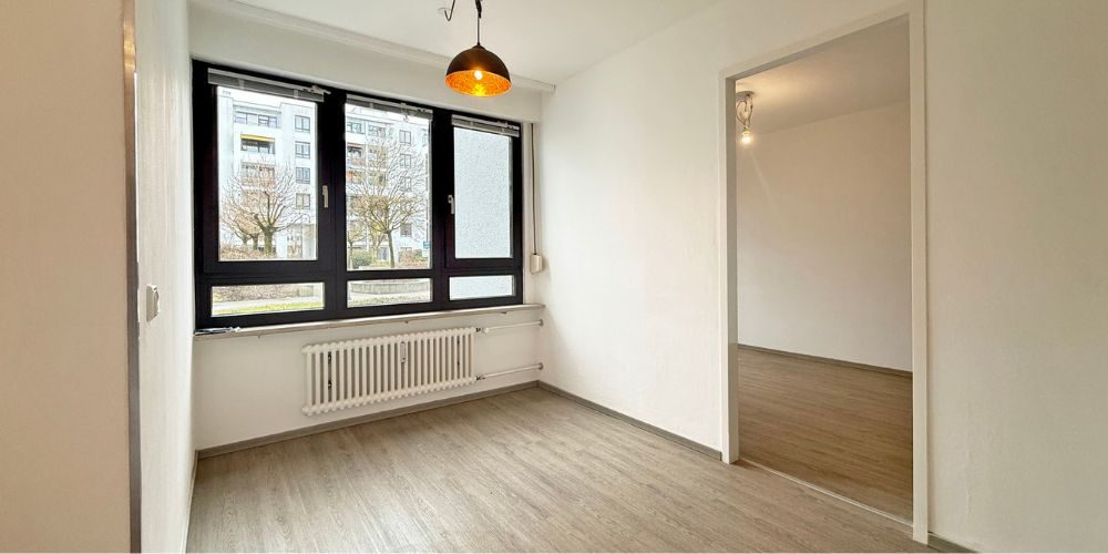 Helles Zimmer mit großen Fenstern und modernem Vinylboden in München