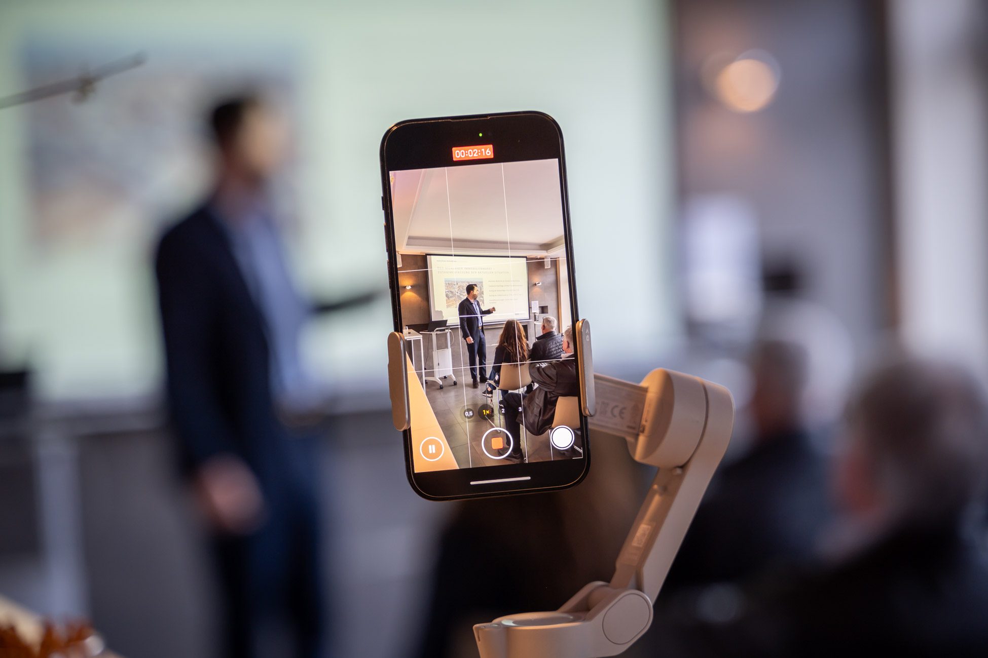 Handy welches den Vortrag von Aigner Immobilien aufnimmt für social media