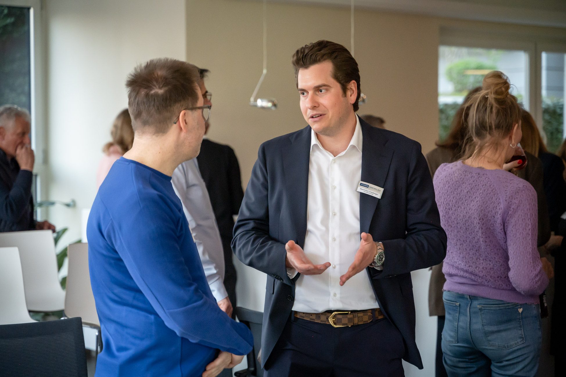 Maximilian Grassberger Immobilienmakler bei Aigner Immobilien in einem Gespräch