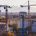 Baustellen und Baukräne vor Münchens Skyline mit Alpenpanorama