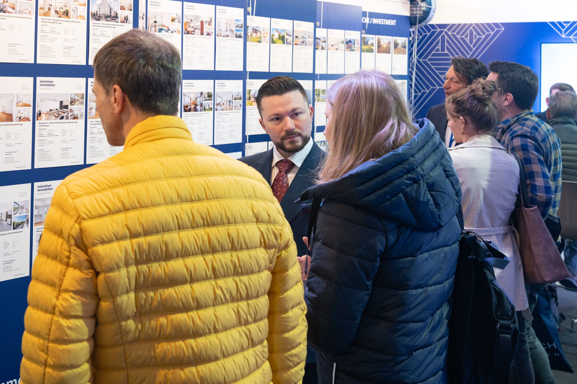 Menschen im Gespräch auf der münchner Immobilienmesse am Stand von Aigner Immobilien