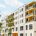 Neubau-Wohnanlage mit Balkonen und Bäumen entlang einer ruhigen Wohnstraße