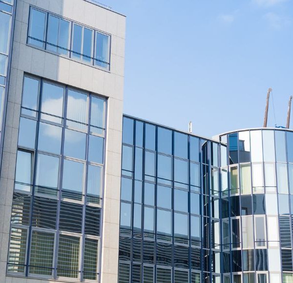 Moderne Bürogebäude mit Glasfronten vor blauem Himmel in Münche