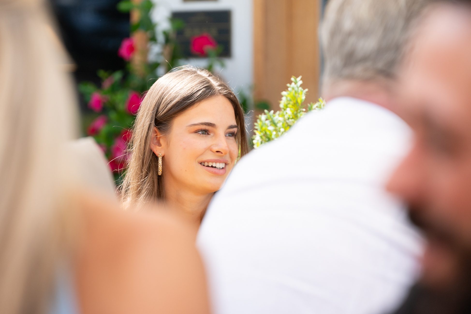 Junge Frau unterhält sich lächelnd beim Aigner Immobilien Sommerfest mit anderen Gästen