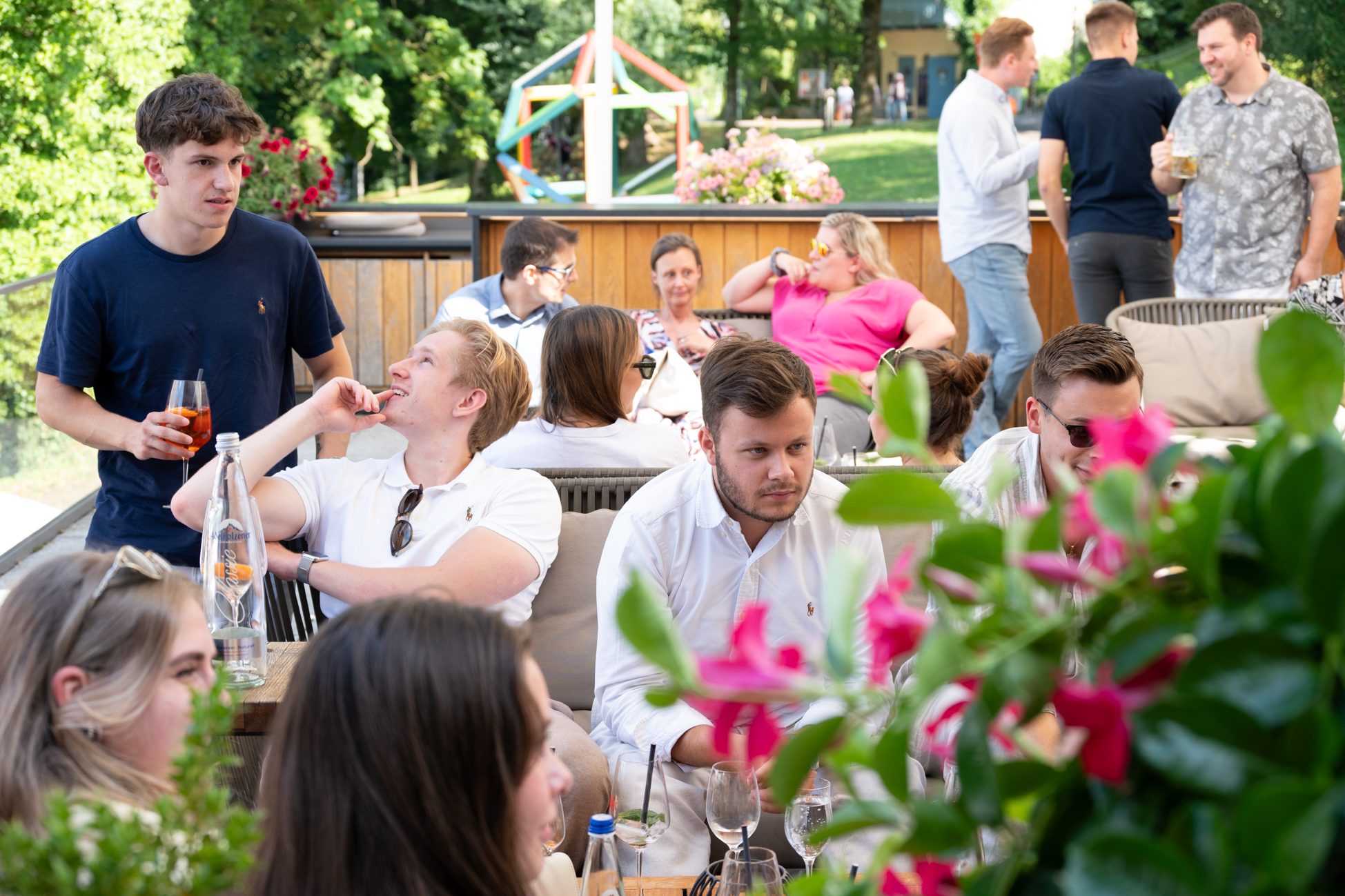 Gäste im Gespräch bei lockerer Atmosphäre und Aperitifs auf der Terrasse