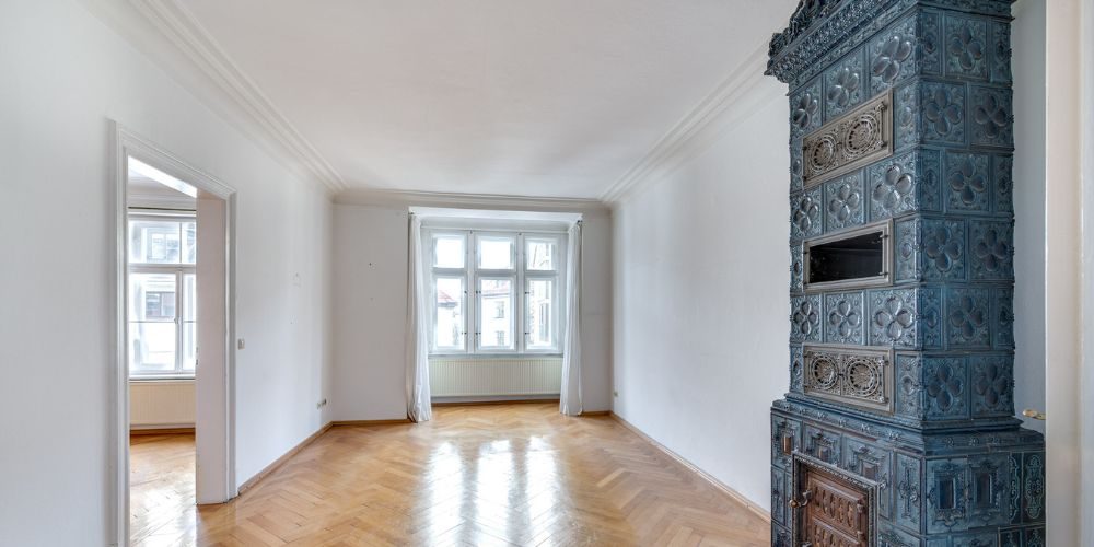 Charmantes Altbauzimmer in München mit historischem Kachelofen (41230) Helles Altbauzimmer in München mit großem Fenster, original Fischgrät-Parkett und kunstvoll verziertem blauen Kachelofen