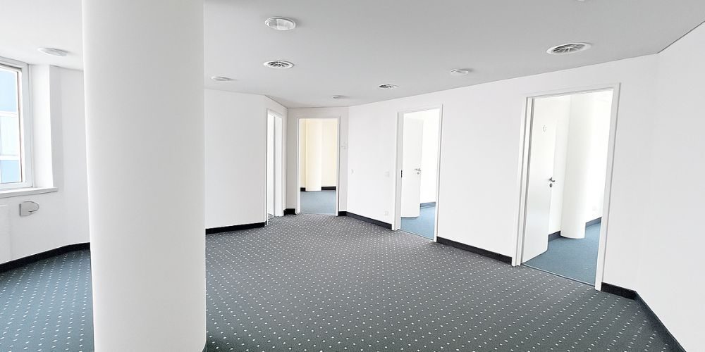 Helle, moderne Bürofläche in München mit Teppichboden, weißen Wänden und mehreren separaten Büroräumen