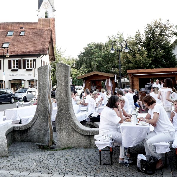 Dinner in White in Pullach. Diverse Menschen in weißer Kleidung beim Dinner unter freiem Himmel