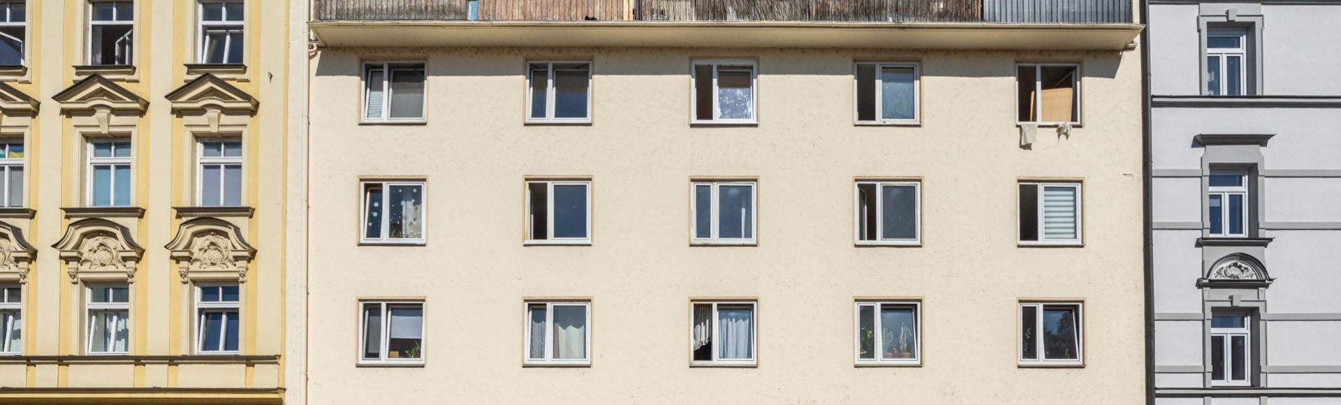 Ansicht einer Wohnhausfassade in hellgelb aus den 1960er Jahren München