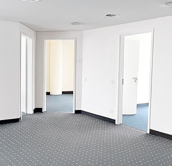 Bürofläche mit weißen Säulen und grauem Teppich