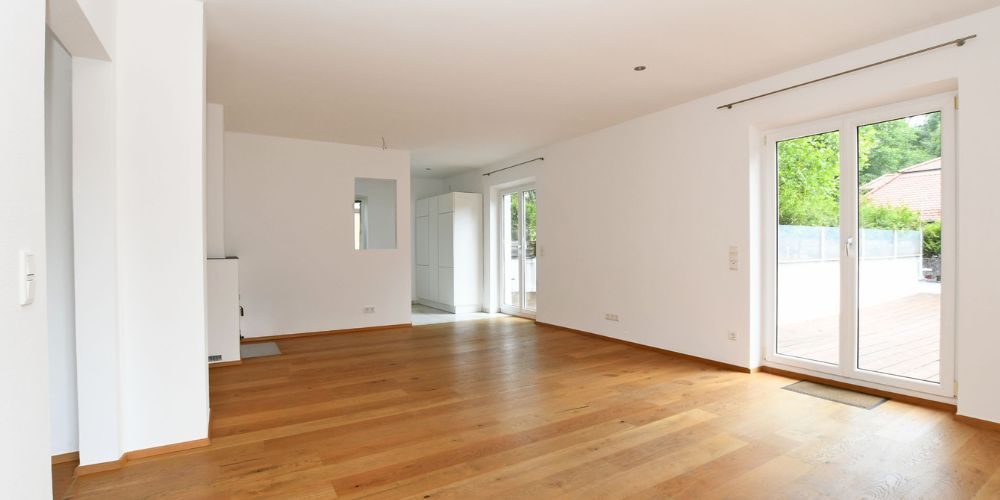 Helles Wohnzimmer mit Parkettboden und Zugang zur Terrasse in München