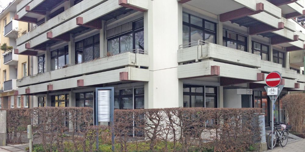 Ältere Büro- und Gewerbeimmobilien mit Wohnungen und großen Balkonen