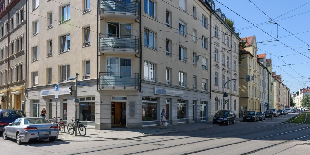 Eckfassade eines Mehrfamilienhauses mit Geschäften im Erdgeschoss