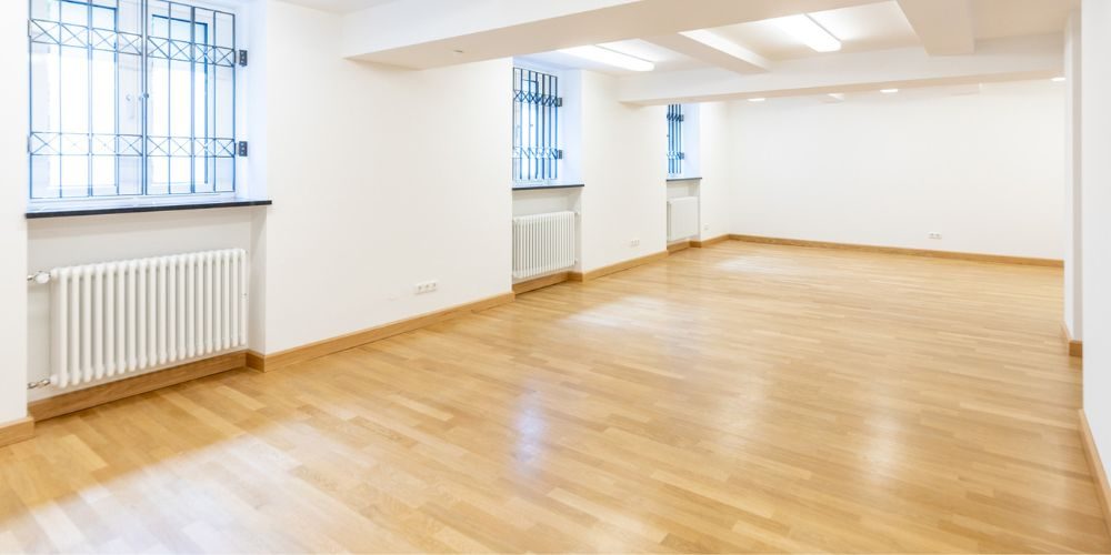 Renovierter Souterrain-Raum mit Tageslicht, Parkettboden und Heizkörpern in einer Münchner Gewerbeeinheit, ideal für Büro, Lagerfläche oder kreative Nutzung