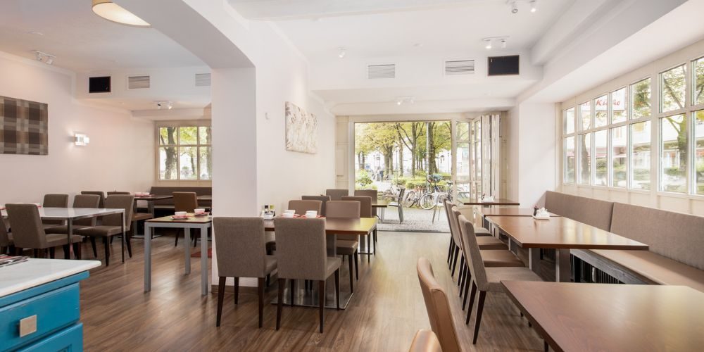 Innenbereich eines Restaurants mit braunen Stühlen und Blick auf eine Terrasse