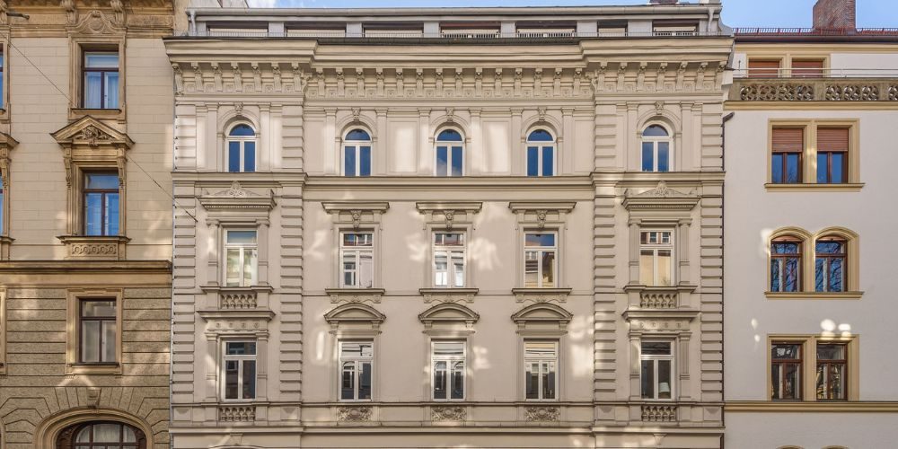 Prächtige Altbaufassade mit Stuckelementen und Rundbogenfenstern in zentraler Lage von München, ideal für exklusive Büroräume oder Praxis im historischen Ambiente