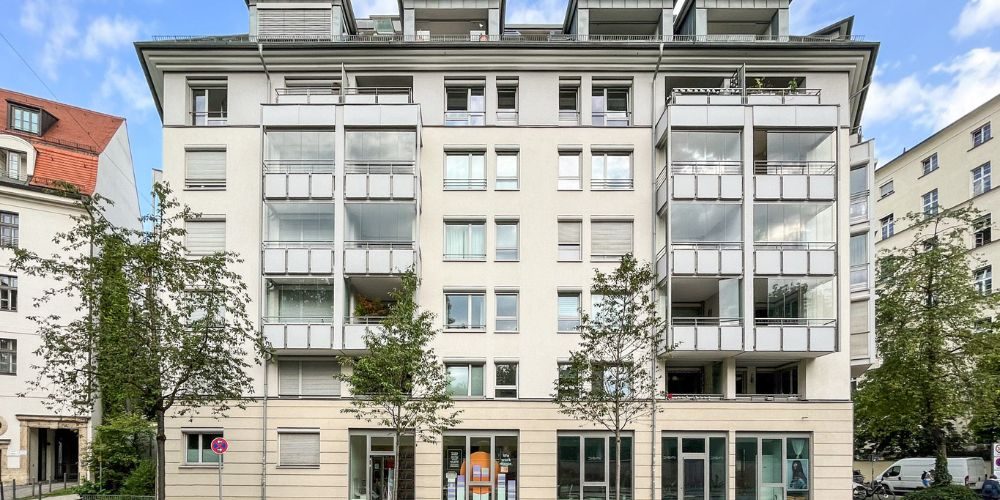 Ansicht eines modernen Wohnhauses mit Läden im Erdgeschoss und verglasten Balkonen