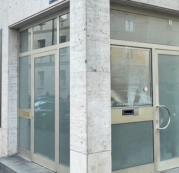 Moderne Gewerbefläche an einer Straßenecke in München mit großen Glasfenstern und heller Natursteinfassade