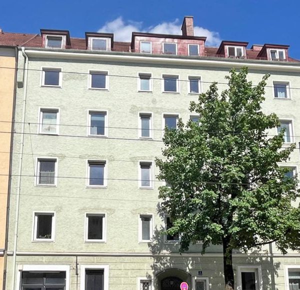 Fassadenansicht mehrerer klassischer Münchner Altbauten mit Geschäften im Erdgeschoss und Wohnraum darüber