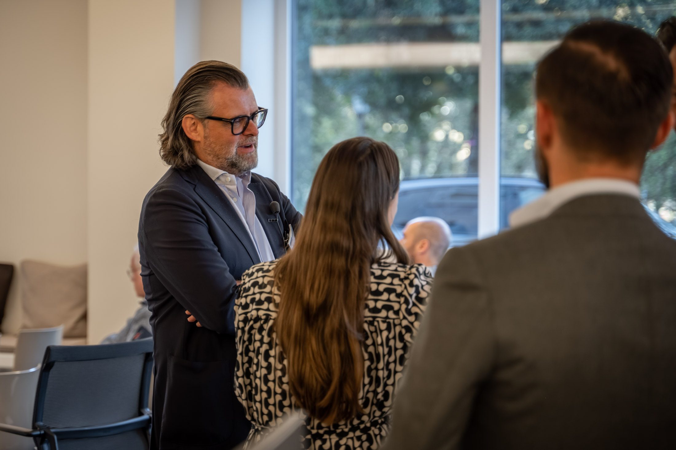 Makler spricht mit Gästen in moderner Immobilienfiliale in München