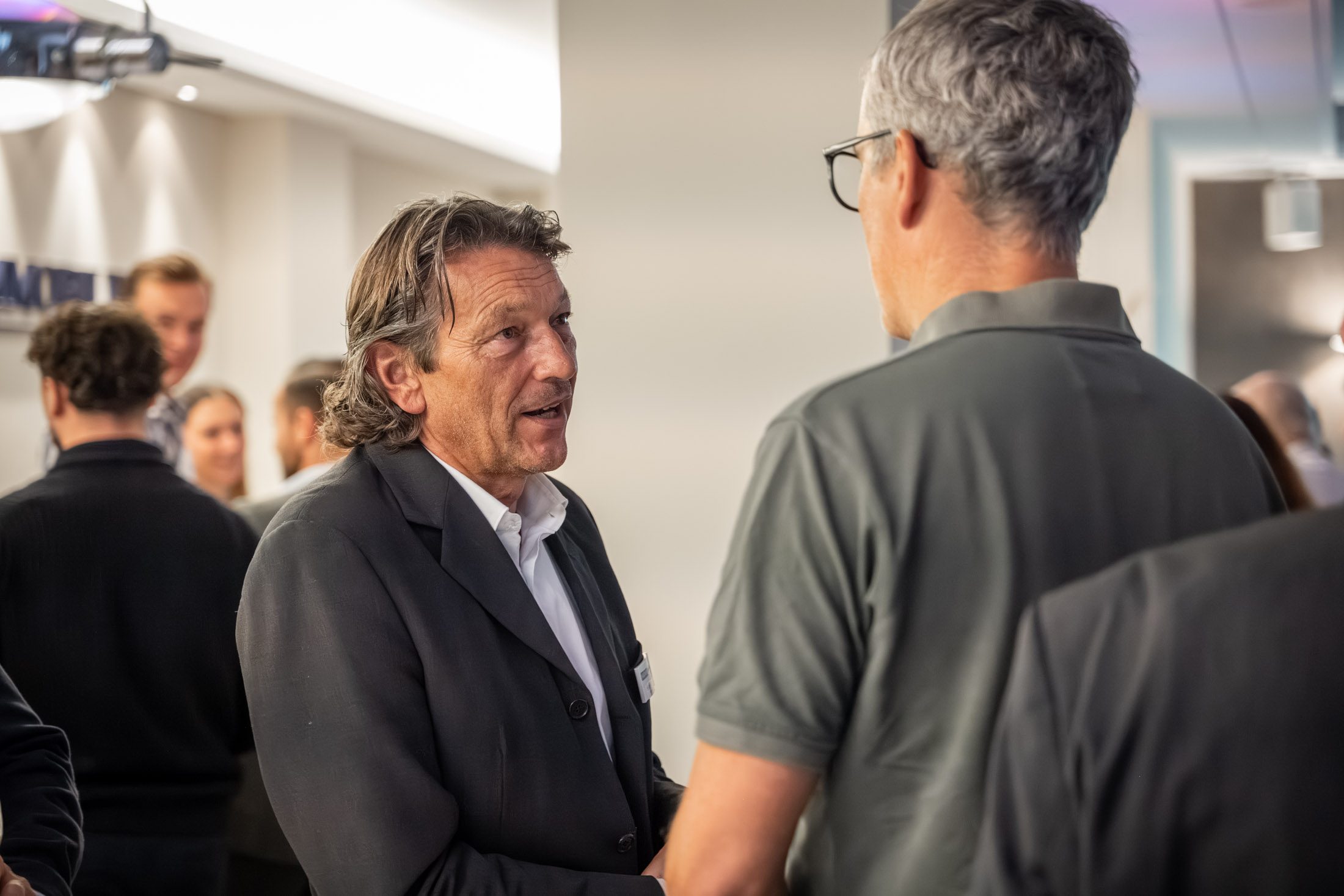 Zwei Männer im Gespräch bei Networking-Event eines Immobilienmaklers