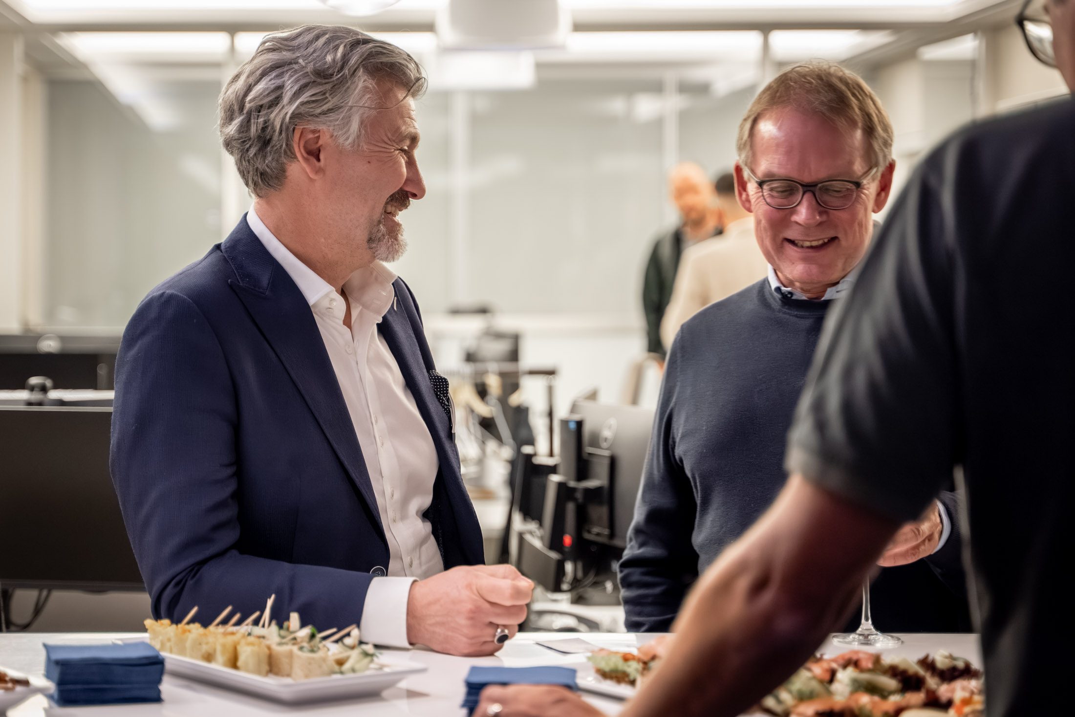 Zwei Männer lachen bei einer Immobilienveranstaltung in München mit Catering