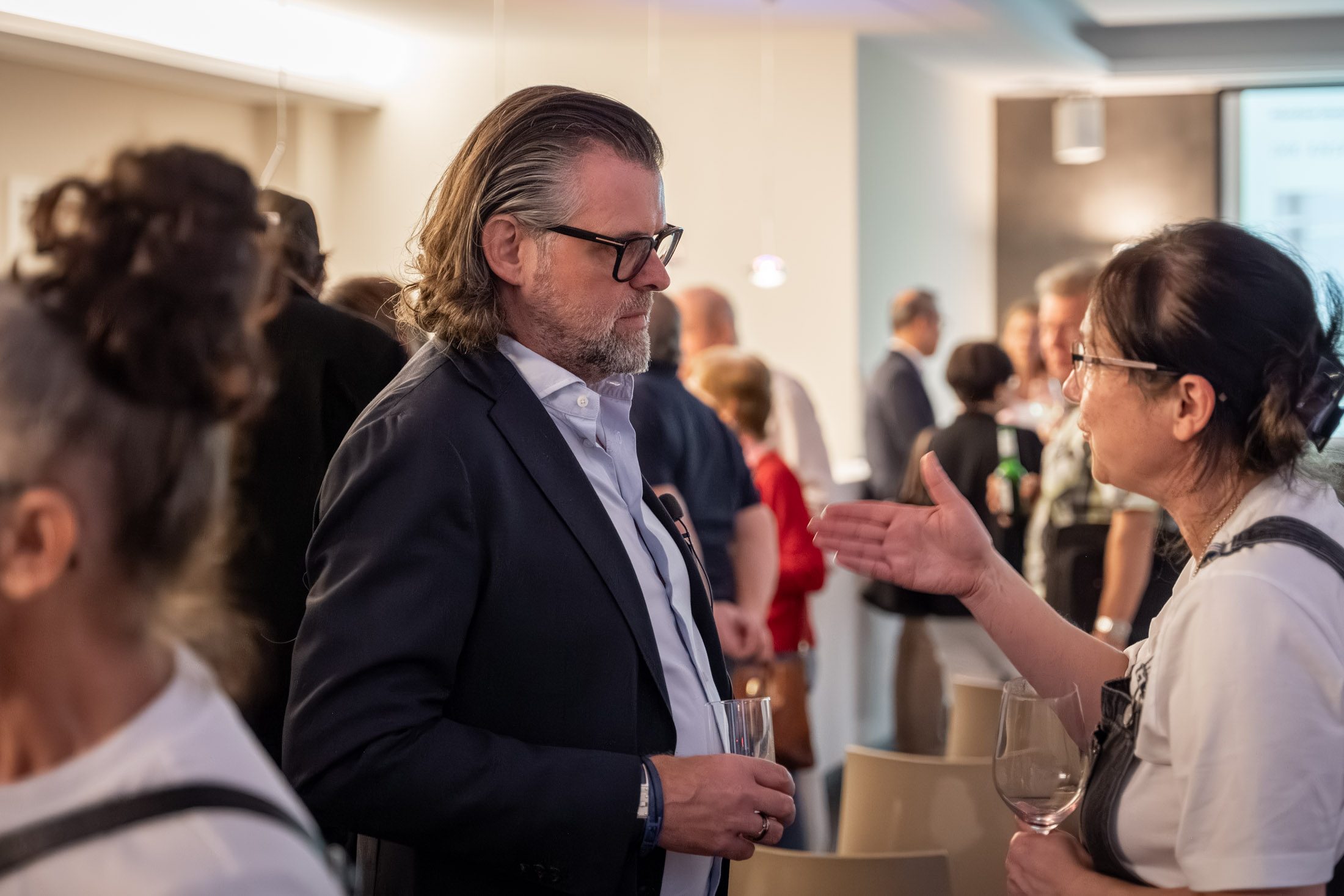 Frau im Gespräch mit Immobilienmakler bei Networking-Event in München