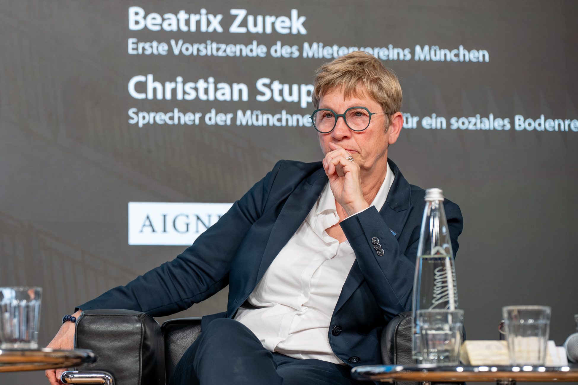 Nachdenkliche Momente beim Immobilien Fokus München Teilnehmerin der Podiumsdiskussion reflektiert Themen zur Wohnungsbaupolitik beim Münchner Immobilien Fokus