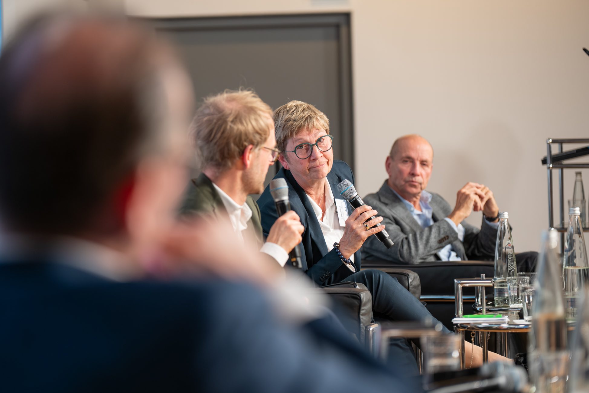 Dialog auf dem Podium beim Immobilien Fokus München Experten im intensiven Austausch über Wohnungsbaupolitik während der Podiumsdiskussion in München