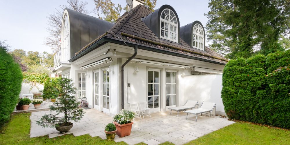 Exklusive, stilvolle Immobilie mit Garten und Sonnenterrasse (29018) Elegantes Einfamilienhaus in München mit geschwungenen Gauben, gepflegter Terrasse und begrüntem Garten in ruhiger Lage