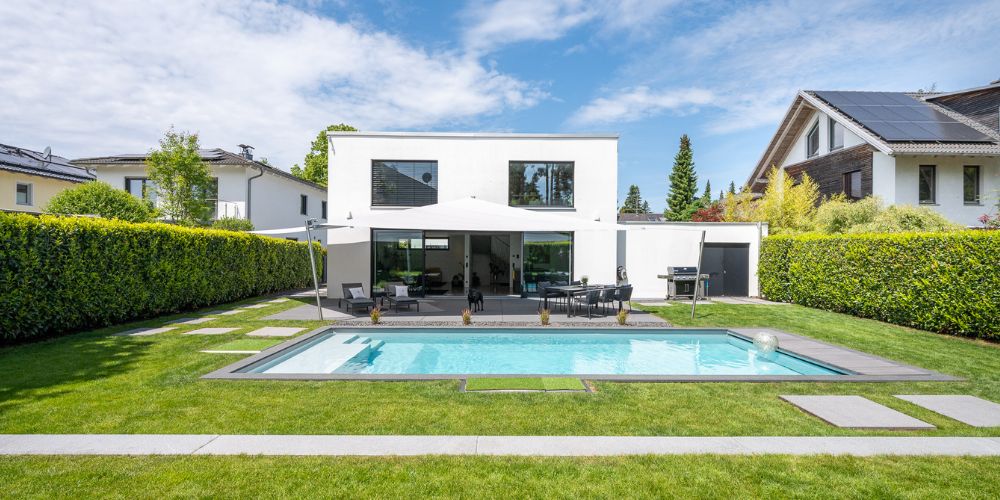 Exklusive Immobilie mit Garten und Pool (41981) Moderne weiße Stadtvilla mit Pool und gepflegtem Garten in einer exklusiven Wohngegend bei Sonnenschein
