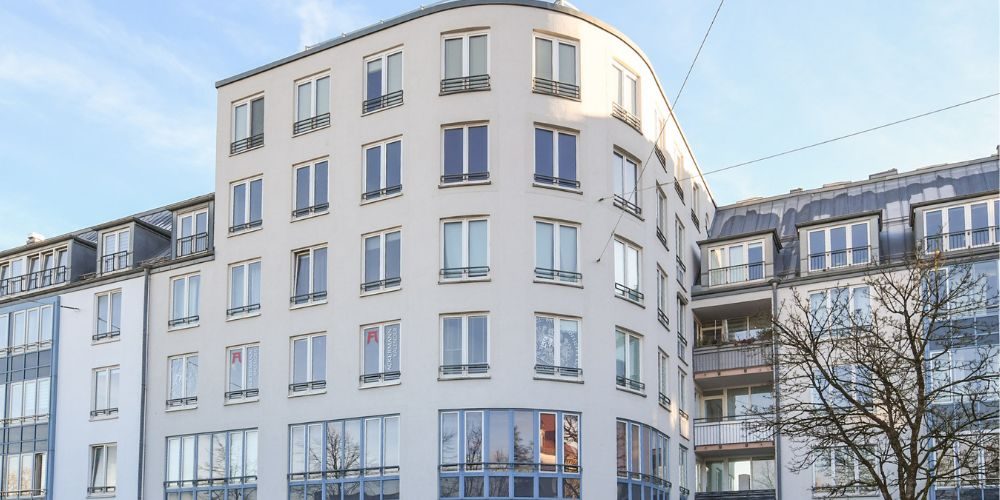 Außenansicht eines modernen, mehrstöckigen Wohngebäudes in München mit großen Fenstern und heller Fassade
