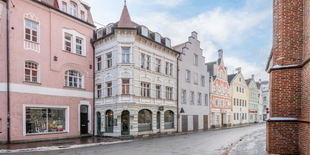 Historische Altstadtstraße mit farbenfrohen Stadthäusern und traditioneller Architektur in Landshut