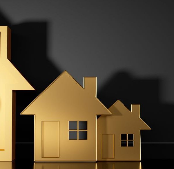 Goldene Häuser mit Paragraphenzeichen als Symbol für Immobilienrecht