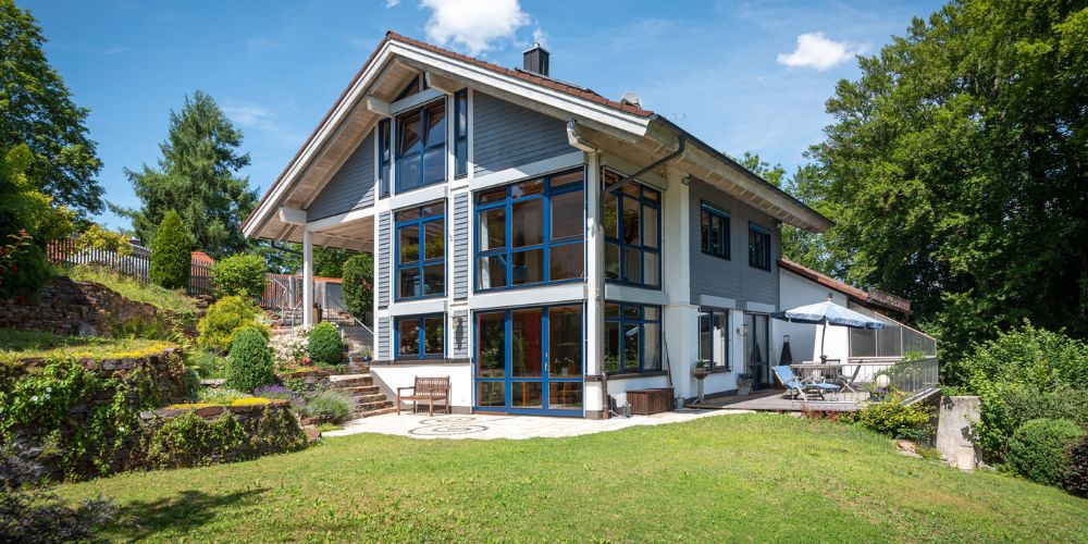 Exklusives Einfamilienhaus in München (33108) Modernes Einfamilienhaus in München mit großzügiger Glasfassade, sonniger Terrasse und gepflegtem Garten in ruhiger, grüner Wohnlage
