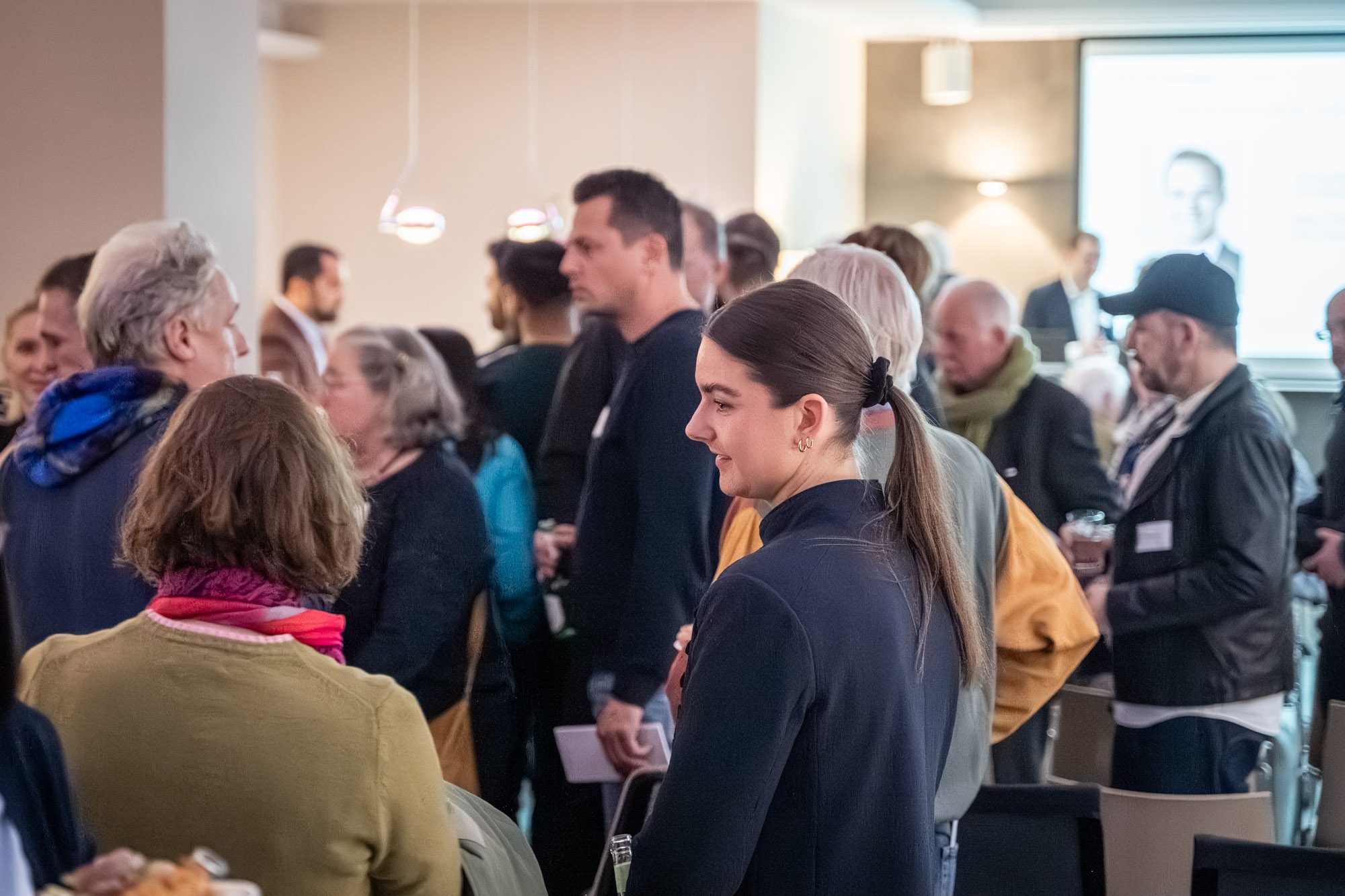 Gäste im Gespräch bei Immobilien-Informationsabend in München mit Maklern von Aigner Immobilien