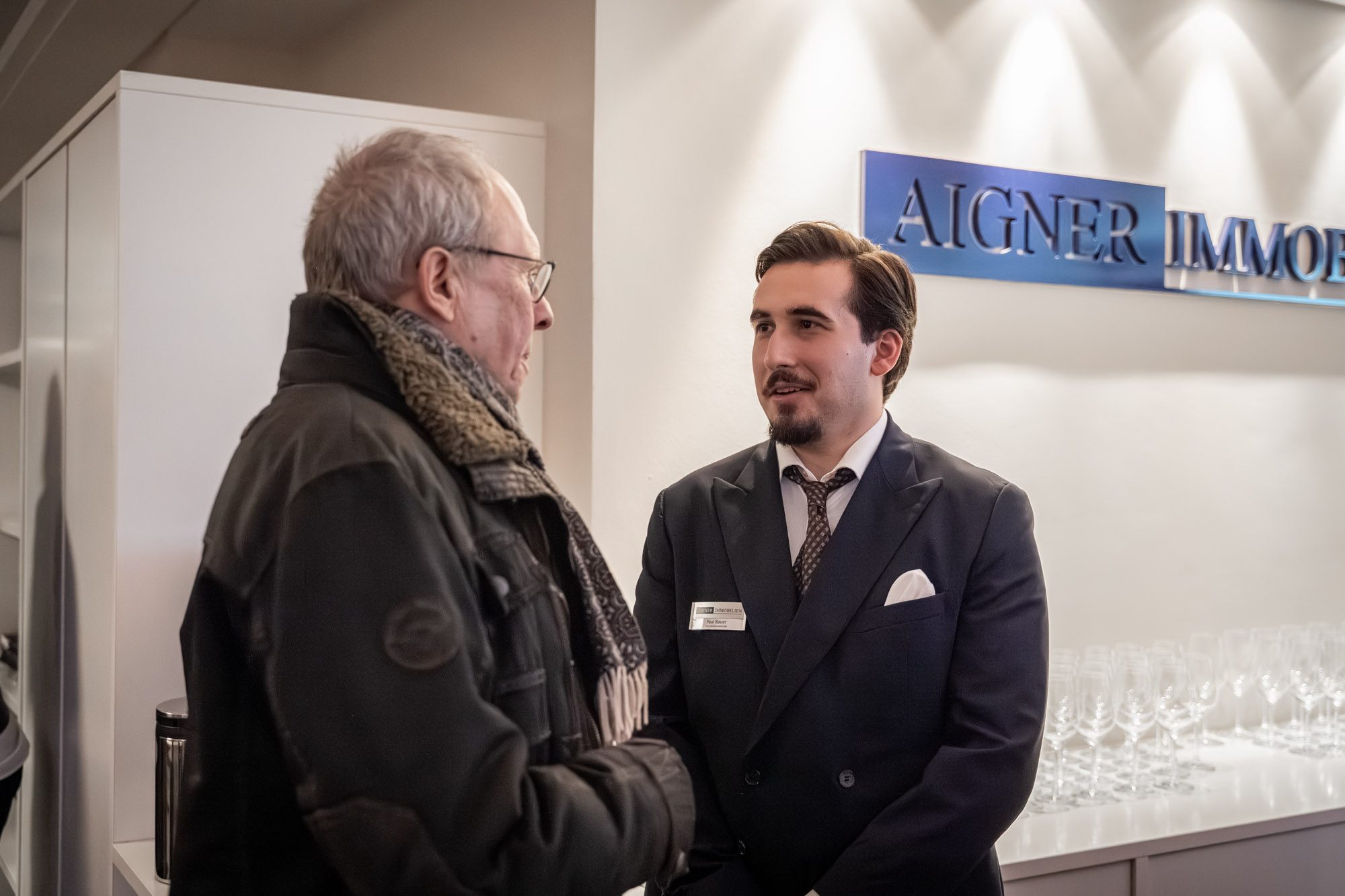 Immobilienberater im Gespräch mit Interessent in modernen Geschäftsräumen in München