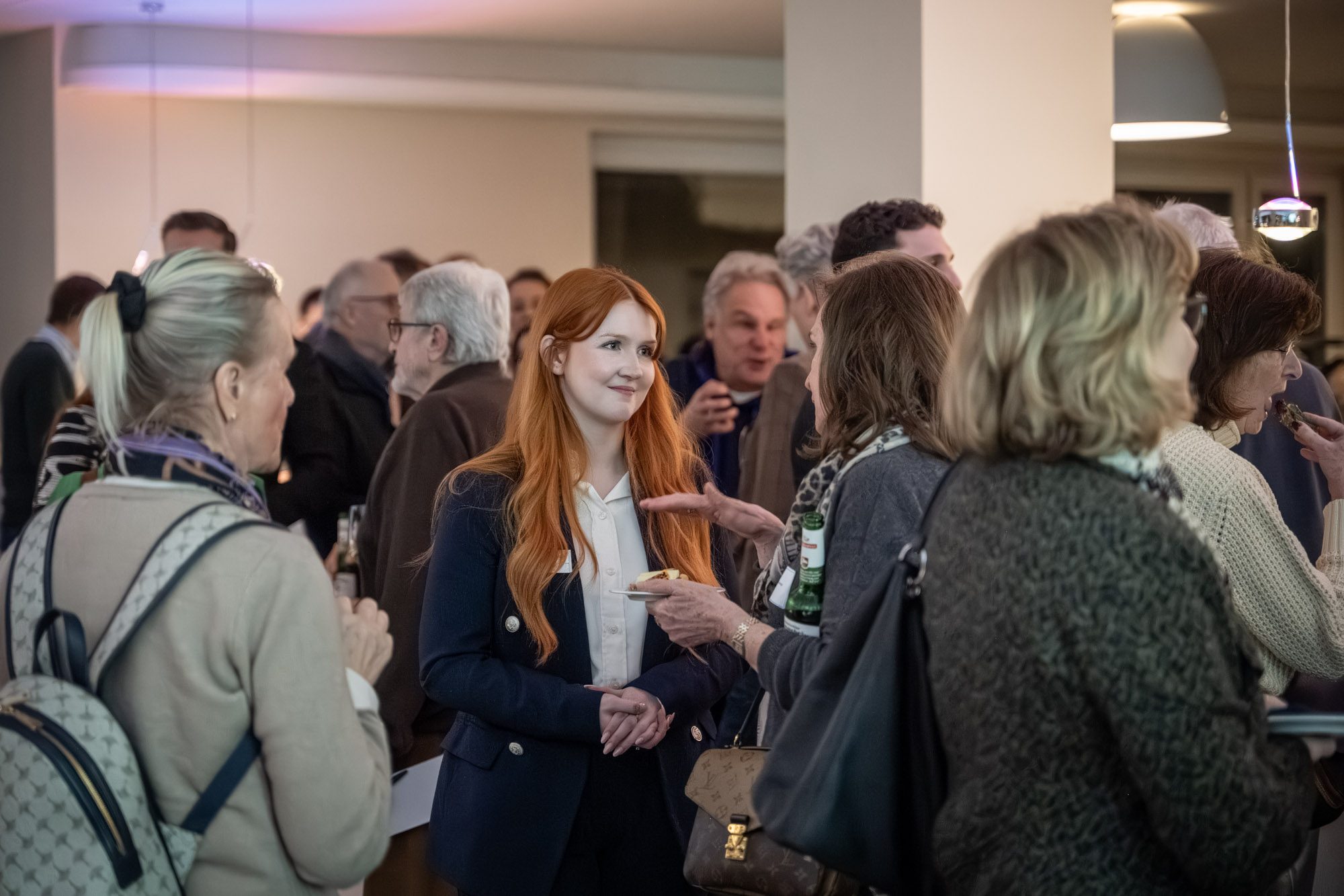 Maklerteam von Aigner Immobilien im Gespräch mit Kunden bei Networking-Veranstaltung in München
