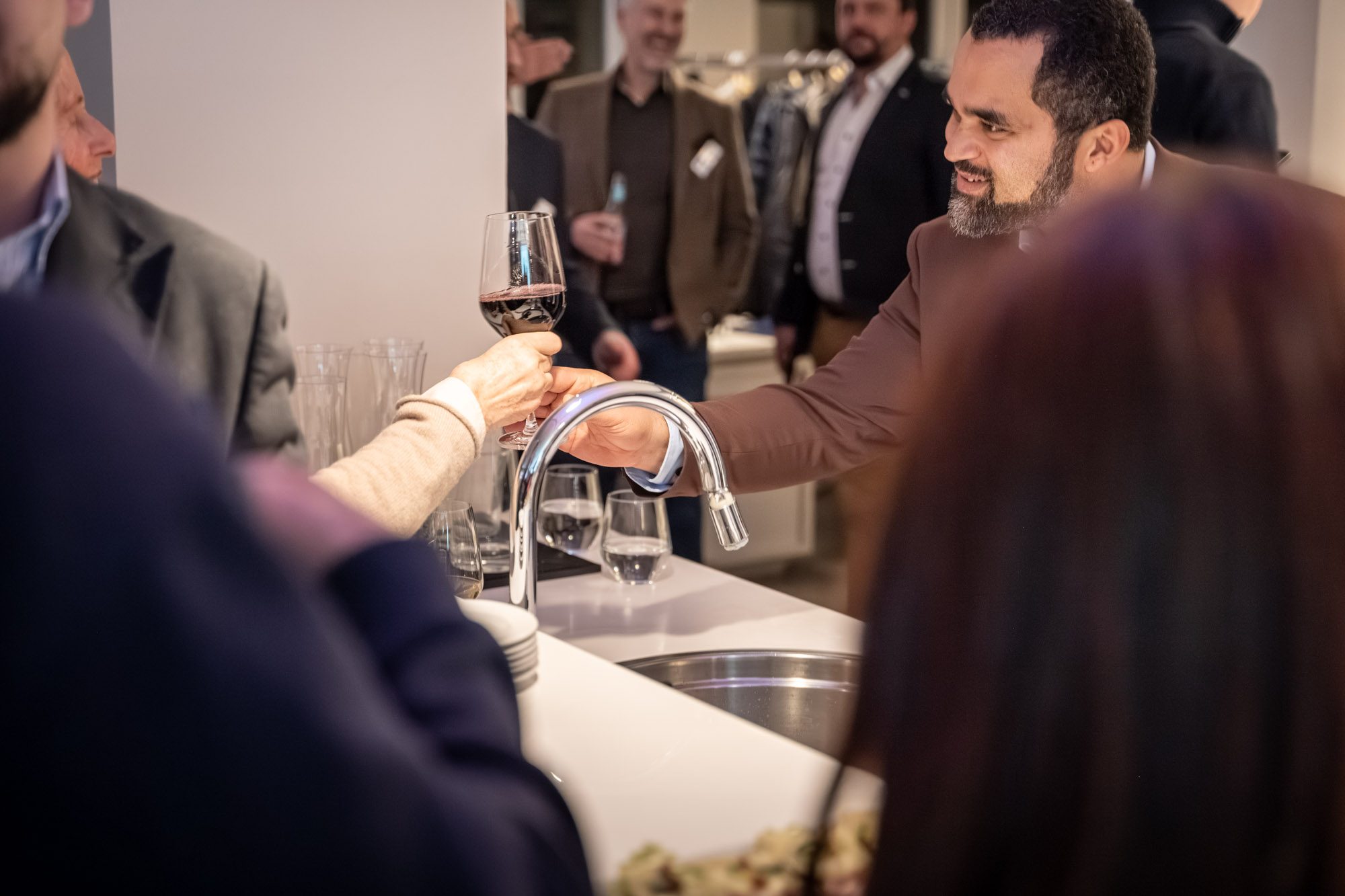 Gäste stoßen mit Wein bei Immobilien-Event in München an